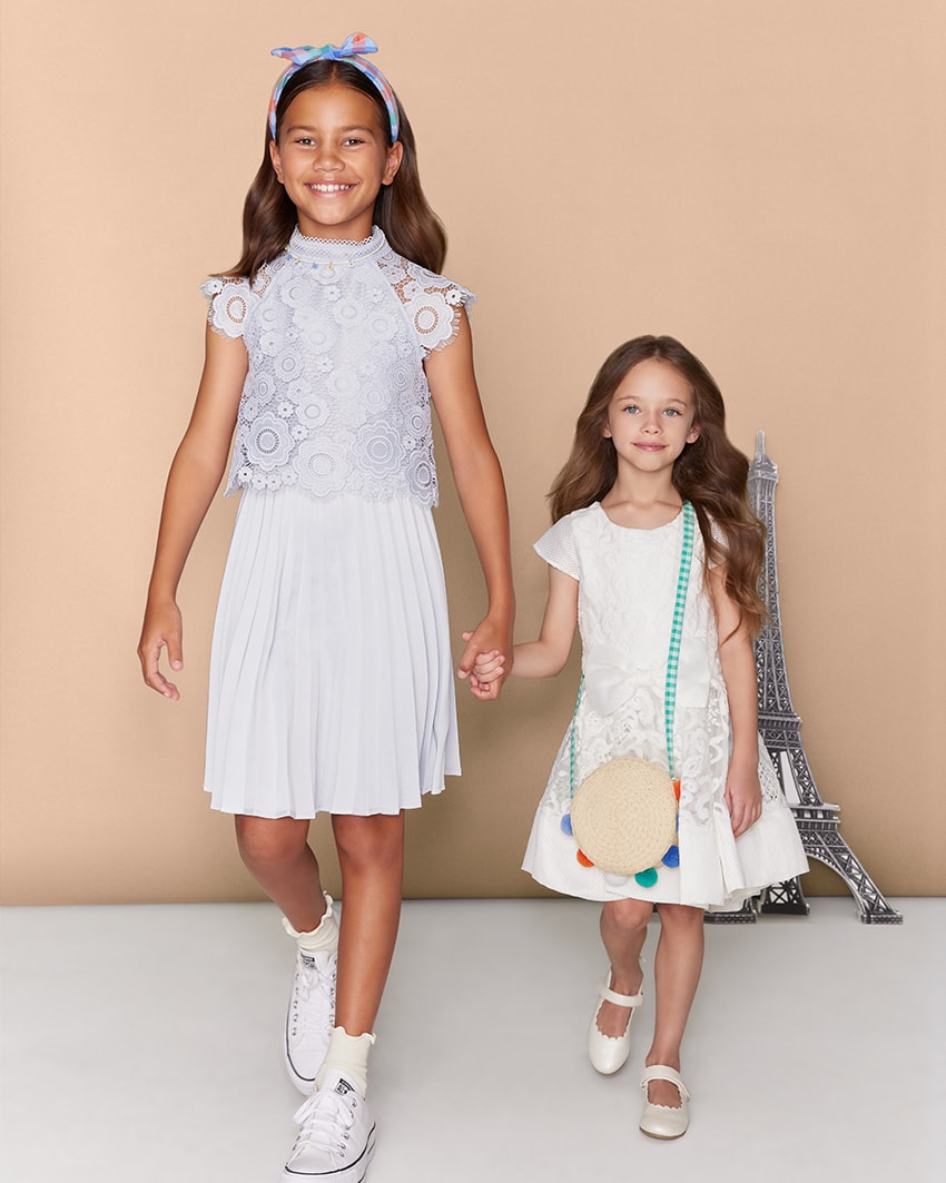 Two girls holding hands, wearing Bardot Junior and Review 